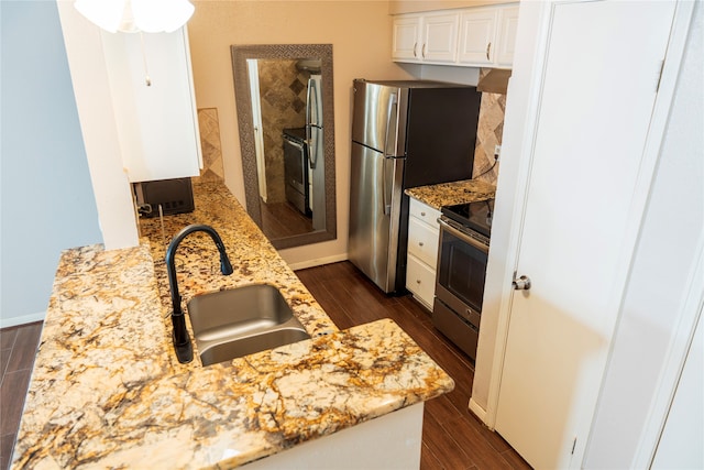 kitchen with sink, electric range, light stone countertops, white cabinets, and dark hardwood / wood-style flooring