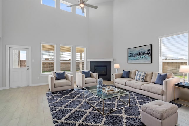 living room with hardwood / wood-style flooring, a high ceiling, and ceiling fan