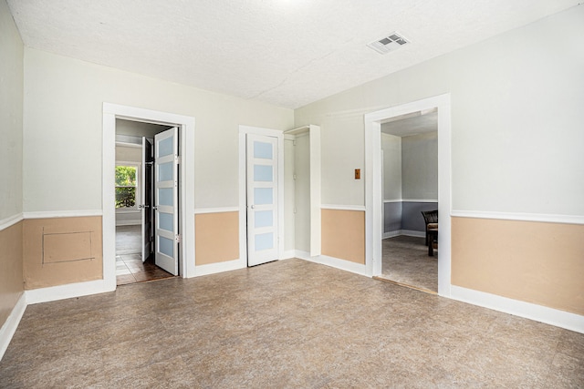 tiled spare room featuring a textured ceiling