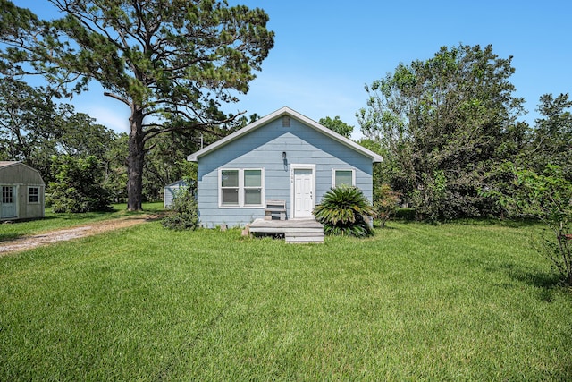 view of front of home featuring an outbuilding and a front lawn