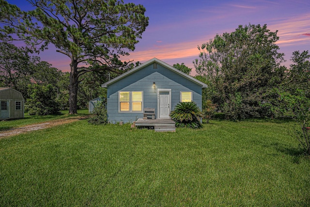 7506 2nd St, Hitchcock, TX 77563 - view of front facade featuring a lawn, an outdoor structure, and a storage shed