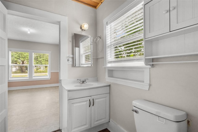 7506 2nd St, Hitchcock, TX 77563 - bathroom featuring toilet, baseboards, and vanity