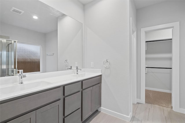 bathroom with vanity and a shower with shower door