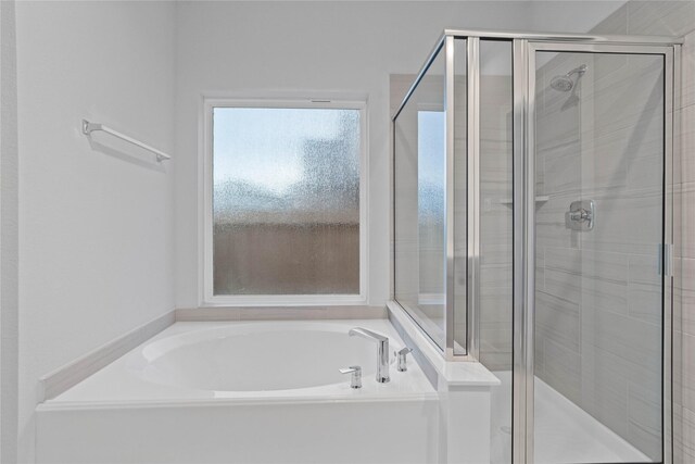 bathroom featuring shower with separate bathtub