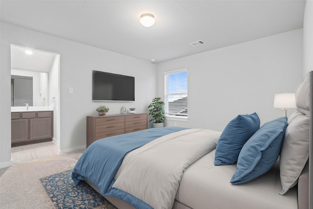 carpeted bedroom featuring sink and connected bathroom