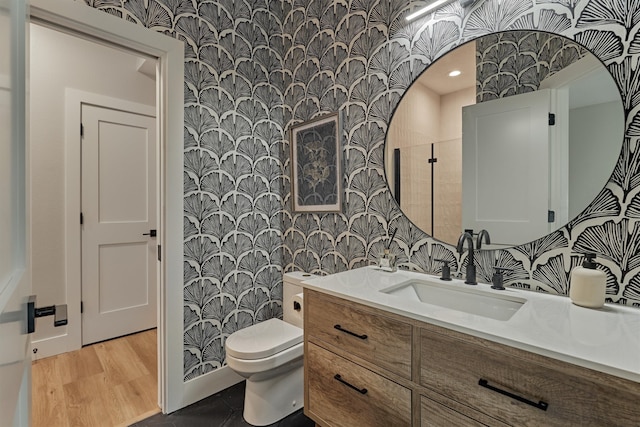 bathroom featuring hardwood / wood-style flooring, toilet, and vanity