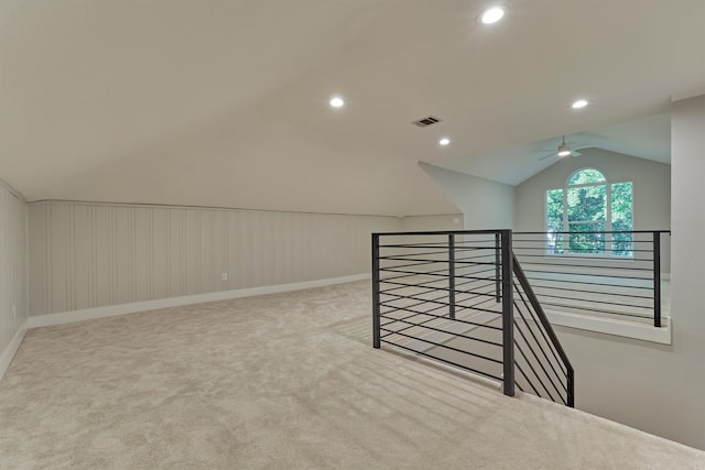 additional living space with ceiling fan, vaulted ceiling, and light colored carpet