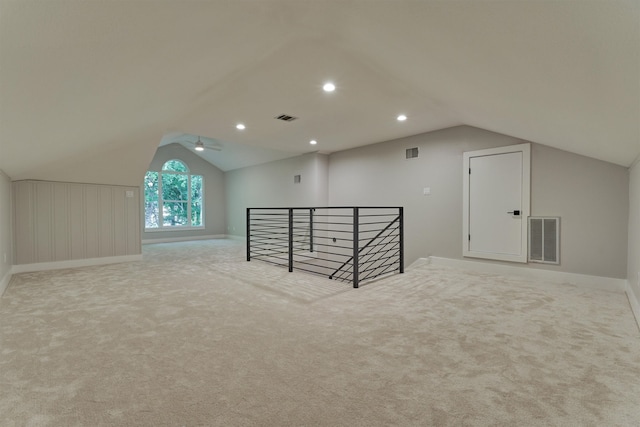 additional living space featuring ceiling fan, lofted ceiling, and light colored carpet