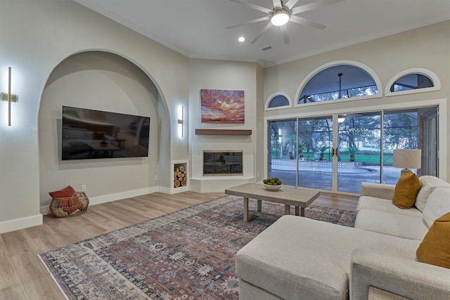 living room featuring ceiling fan, crown molding, and light hardwood / wood-style flooring