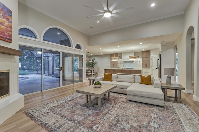 living room featuring a high ceiling, ceiling fan, hardwood / wood-style flooring, and a wealth of natural light