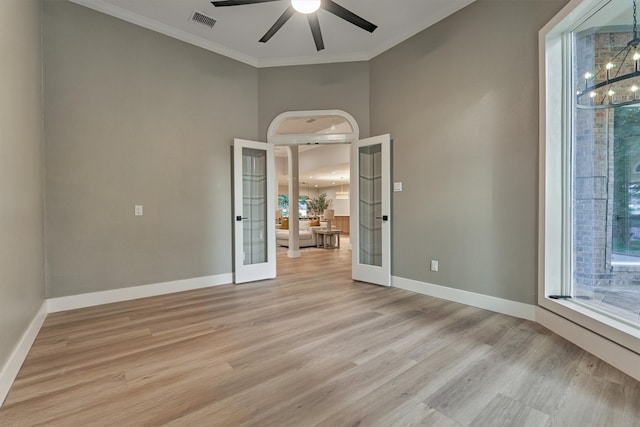 interior space with light hardwood / wood-style flooring, ceiling fan with notable chandelier, ornamental molding, a towering ceiling, and french doors