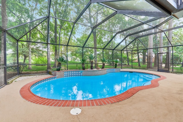 view of swimming pool featuring glass enclosure and a patio