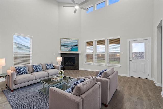 living room featuring a high ceiling, hardwood / wood-style floors, and ceiling fan