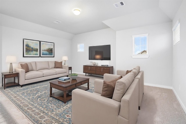 living room featuring vaulted ceiling, a healthy amount of sunlight, and carpet floors