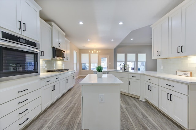 kitchen with sink, appliances with stainless steel finishes, a center island, and kitchen peninsula