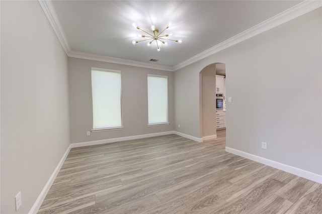 unfurnished room with ornamental molding, light hardwood / wood-style floors, and a notable chandelier