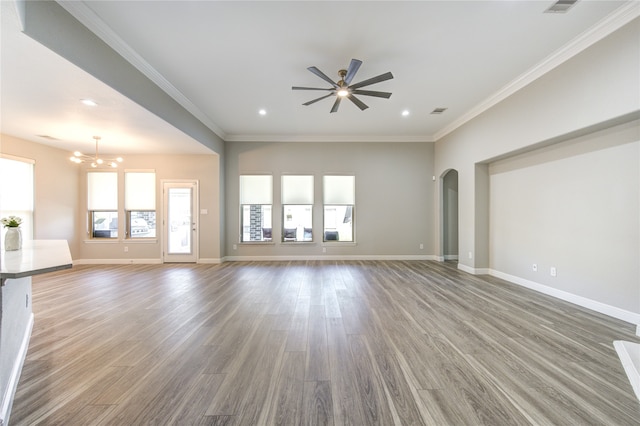 unfurnished living room with crown molding, ceiling fan with notable chandelier, and hardwood / wood-style flooring