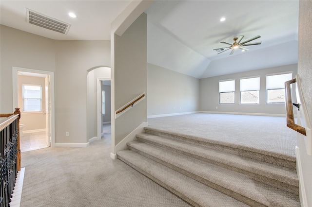 staircase featuring ceiling fan, carpet floors, and lofted ceiling