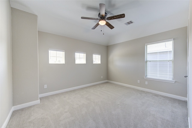 carpeted spare room featuring ceiling fan and vaulted ceiling