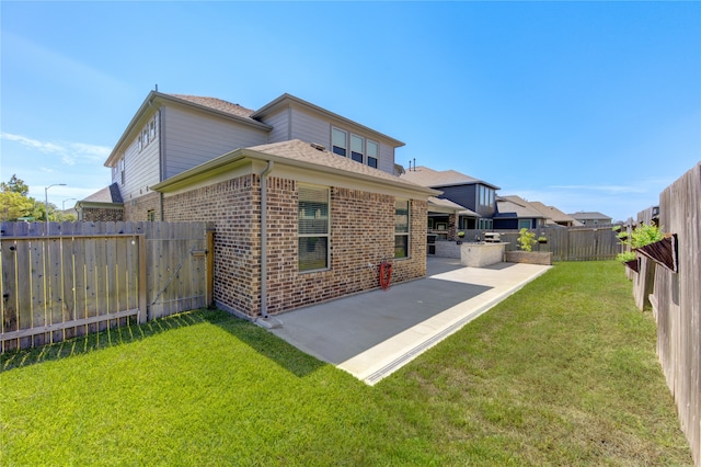 rear view of house with exterior kitchen, a yard, and a patio