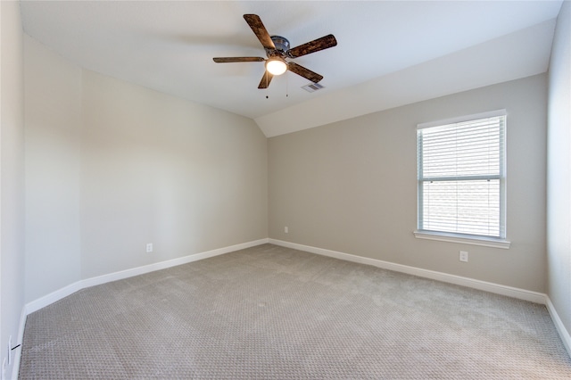 carpeted spare room featuring ceiling fan and lofted ceiling