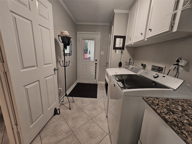 clothes washing area with washer and dryer, cabinets, light tile patterned floors, a textured ceiling, and crown molding