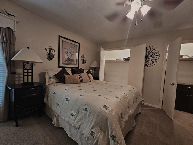 bedroom featuring a closet, carpet floors, a spacious closet, a textured ceiling, and ceiling fan