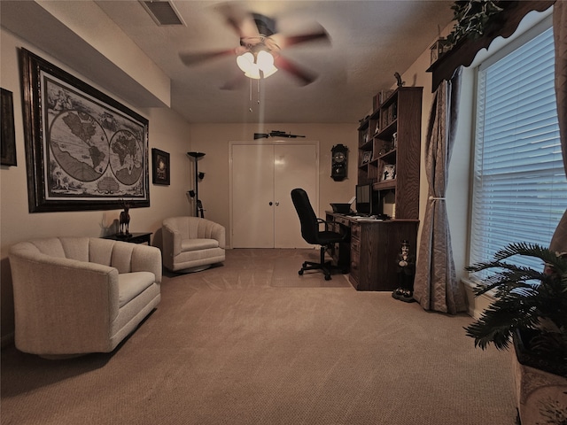 carpeted office featuring ceiling fan