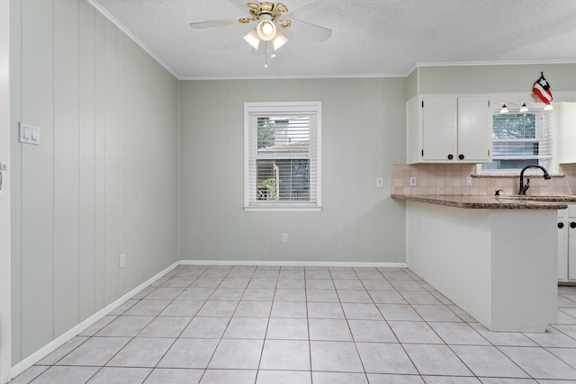 kitchen with decorative backsplash, a textured ceiling, white cabinets, light tile patterned floors, and ceiling fan