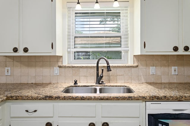 kitchen featuring decorative backsplash, a wealth of natural light, white cabinetry, white dishwasher, and sink