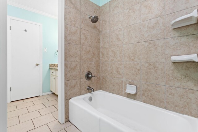 bathroom featuring tiled shower / bath, tile patterned flooring, vanity, and ornamental molding