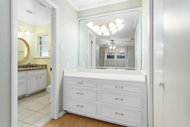 bathroom with hardwood / wood-style flooring, vanity, ceiling fan, crown molding, and toilet