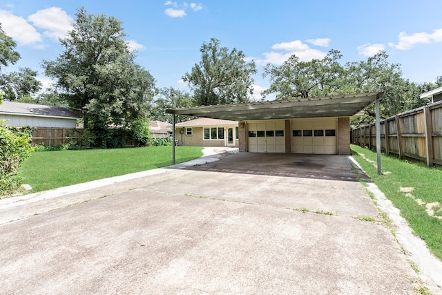 ranch-style house featuring a garage, a front lawn, and a carport