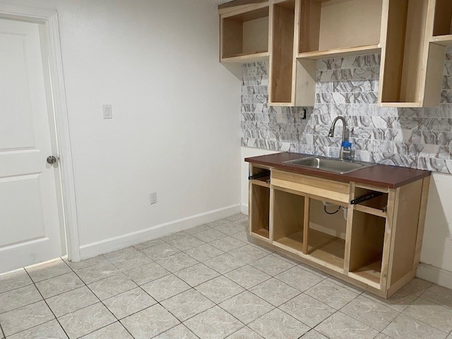 kitchen with sink, decorative backsplash, and light tile patterned floors