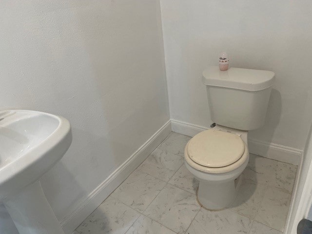 bathroom featuring sink, toilet, and tile patterned flooring