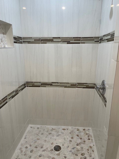 bathroom with a shower and tile patterned flooring