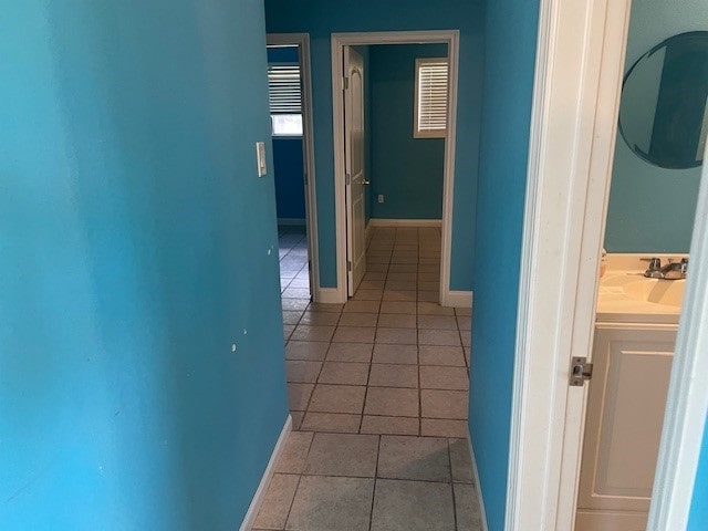 hallway with sink and light tile patterned flooring