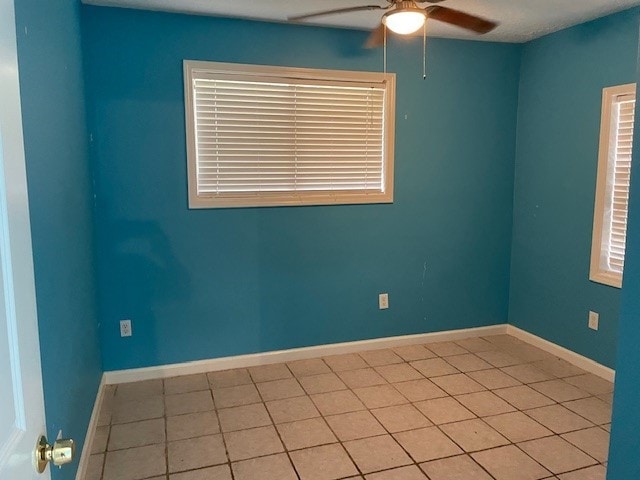 spare room featuring ceiling fan and light tile patterned floors