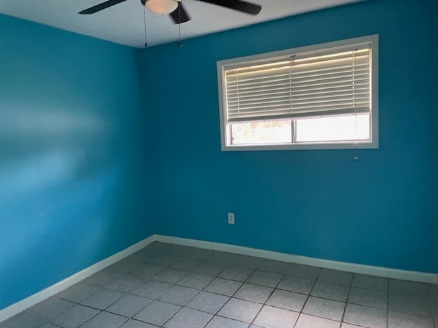 tiled spare room with ceiling fan