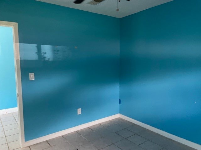 tiled empty room with ceiling fan