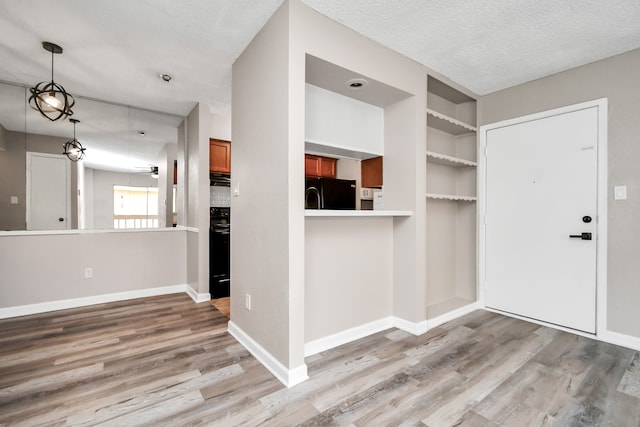 entrance foyer with a textured ceiling and light hardwood / wood-style flooring