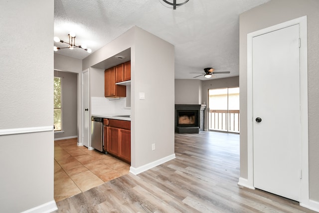 kitchen featuring a textured ceiling, light hardwood / wood-style flooring, ceiling fan with notable chandelier, and dishwasher