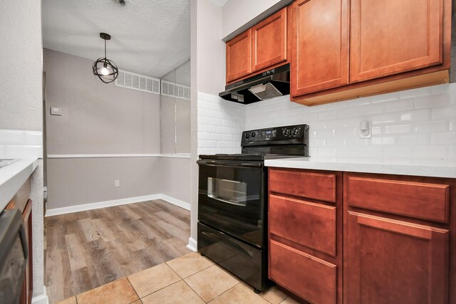 kitchen featuring pendant lighting, light hardwood / wood-style flooring, backsplash, dishwasher, and black / electric stove