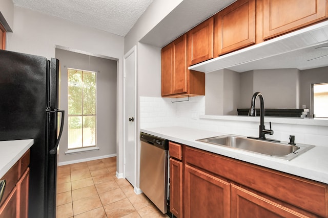 kitchen featuring stainless steel dishwasher, a healthy amount of sunlight, black fridge, and decorative backsplash