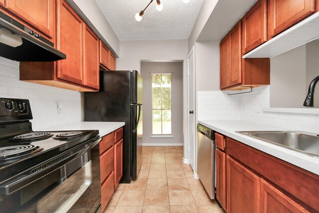 kitchen featuring black appliances, tasteful backsplash, light tile patterned flooring, and a textured ceiling