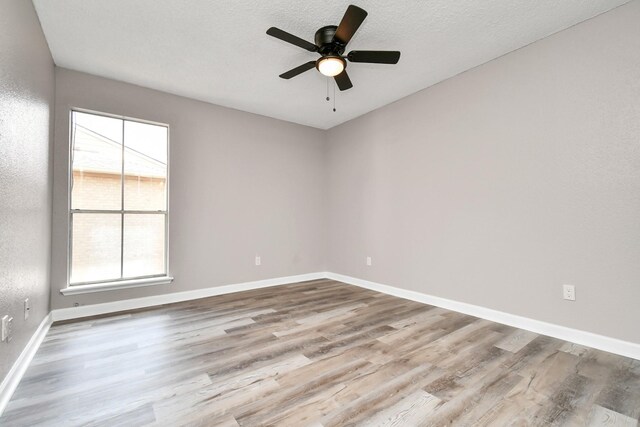 empty room with ceiling fan and wood-type flooring