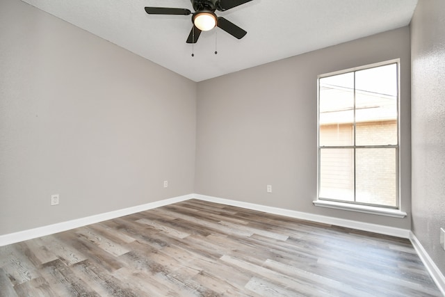 empty room with hardwood / wood-style floors and ceiling fan