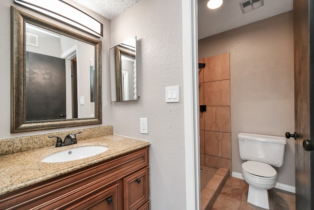 bathroom featuring a textured ceiling, vanity, walk in shower, tile patterned flooring, and toilet