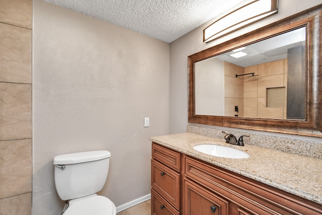 bathroom with toilet, a tile shower, a textured ceiling, and vanity