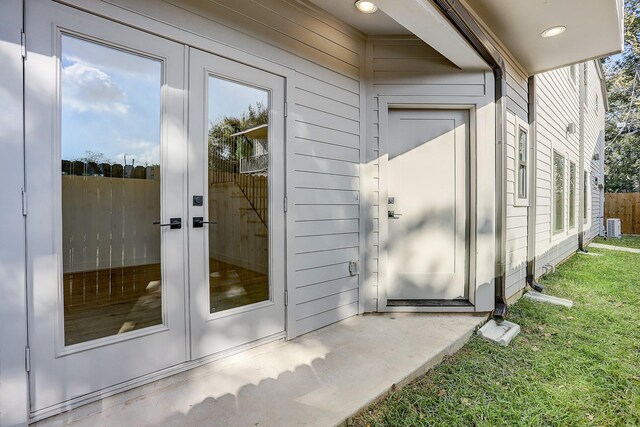 entrance to property featuring a yard and french doors